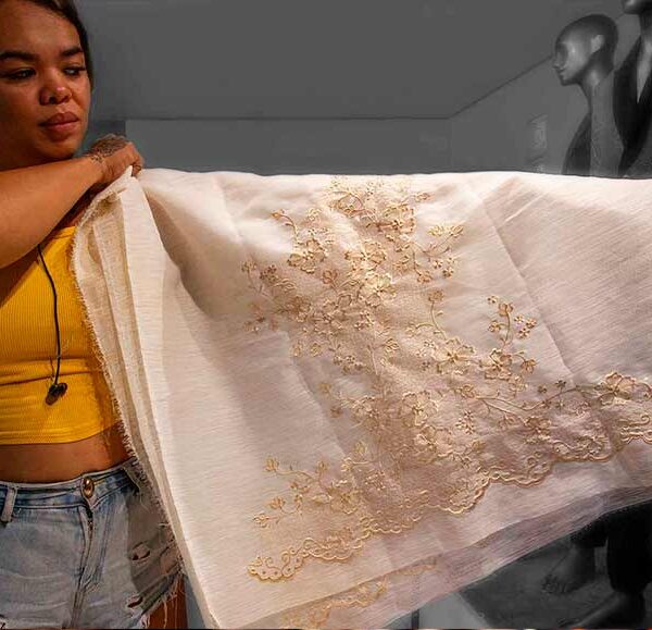 Designer Josip Tumapa showcasing piña jusi fabric with intricate golden embroidery
