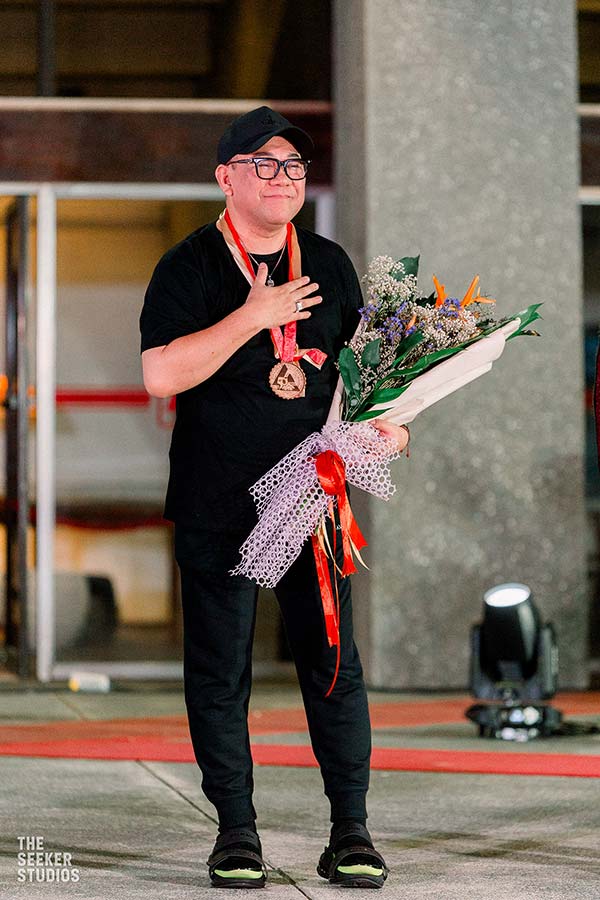 Amir Sali, honored designer at To The Golden Age, holding a bouquet
