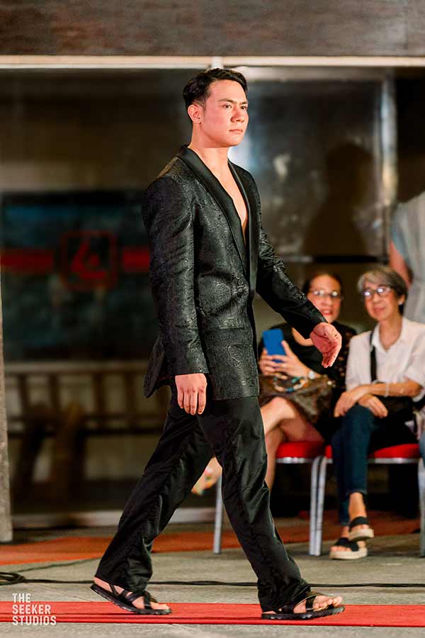 male model in a black embroidered suit on the runway in Dumaguete