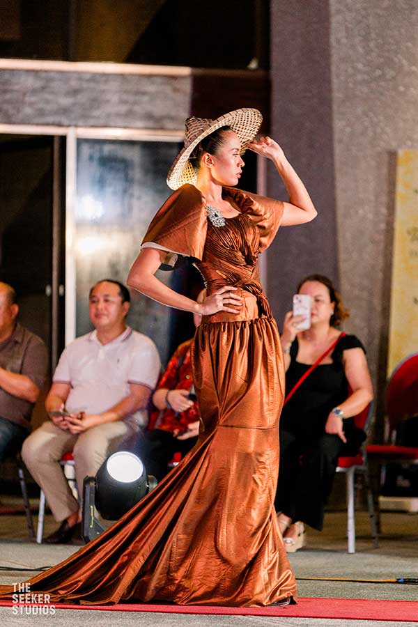 Model in a copper gown by Josip Tumapa walking the runway at Dumaguete Fashion Show