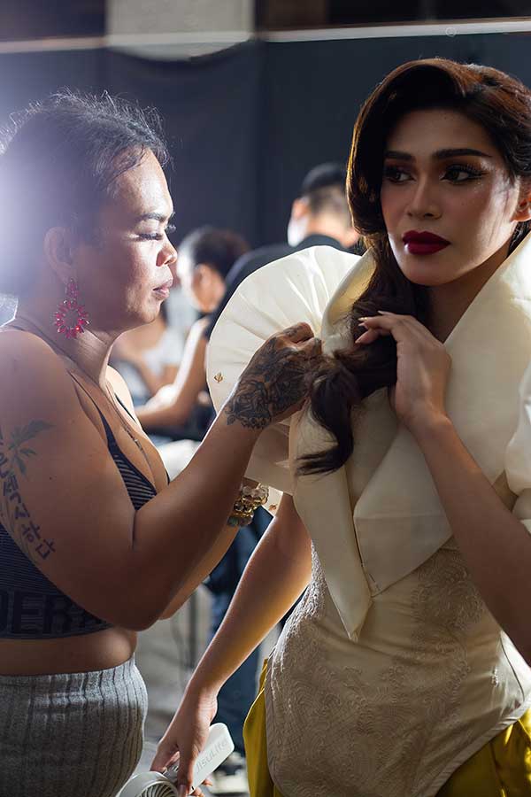Designer Josip Tumapa adjusts a model's Barong Jusi dress before the fashion show