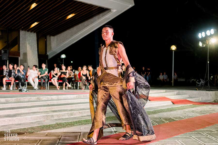 model in a bold Josip Tumapa brown and gold outfit with a cape at Silliman University