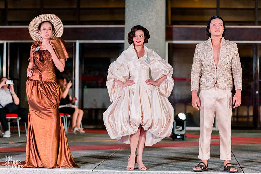 three models wearing outfits from Josip Tumapa's collection on the runway