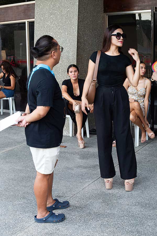 Makeup artist Ian Roy and models take a break during rehearsals for the fashion show in Dumaguete