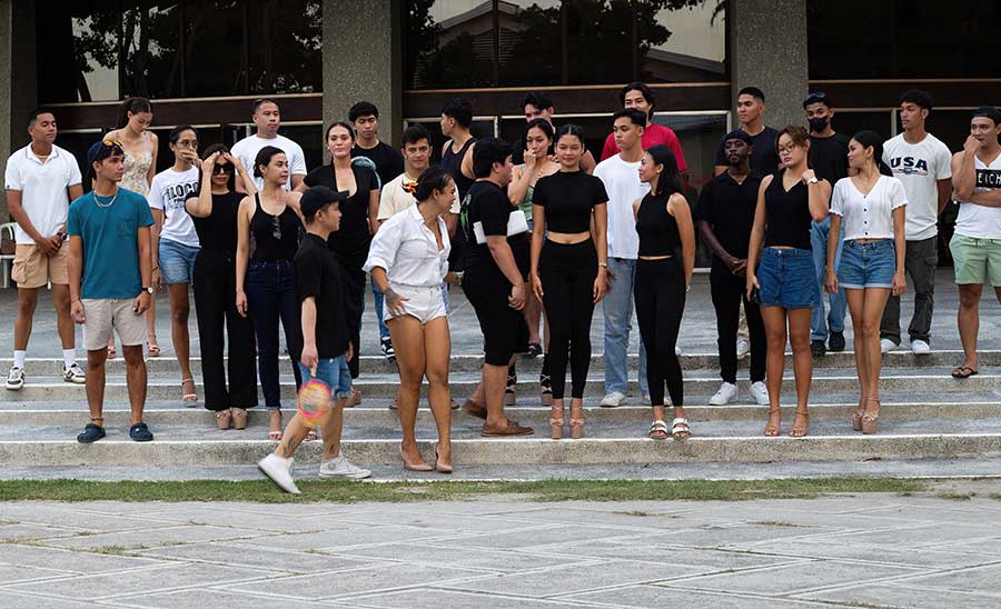 Group of models gathering outside for rehearsals at Claire Isabel McGill Luce Auditorium, led by Josip Tumapa