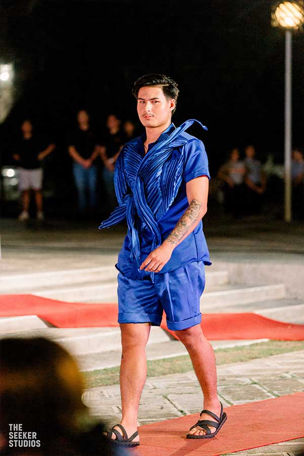 model in a pleated royal blue ensemble walking the runway at a fashion show in the Philippines