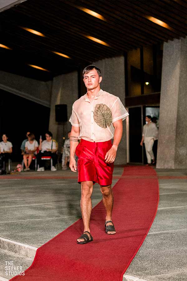 male model walking in red Mikado shorts and Jusi Organza top on the catwalk