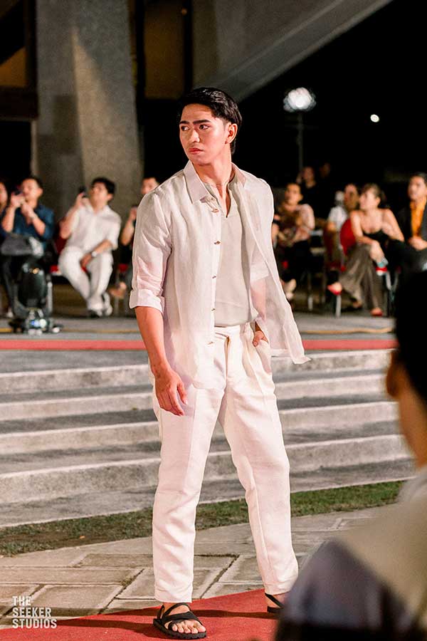 model in an elegant white linen ensemble on the runway at a fashion show in the Philippines