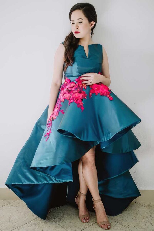 Custom-designed blue layered gown with bold pink floral accents – a statement in bespoke tailoring