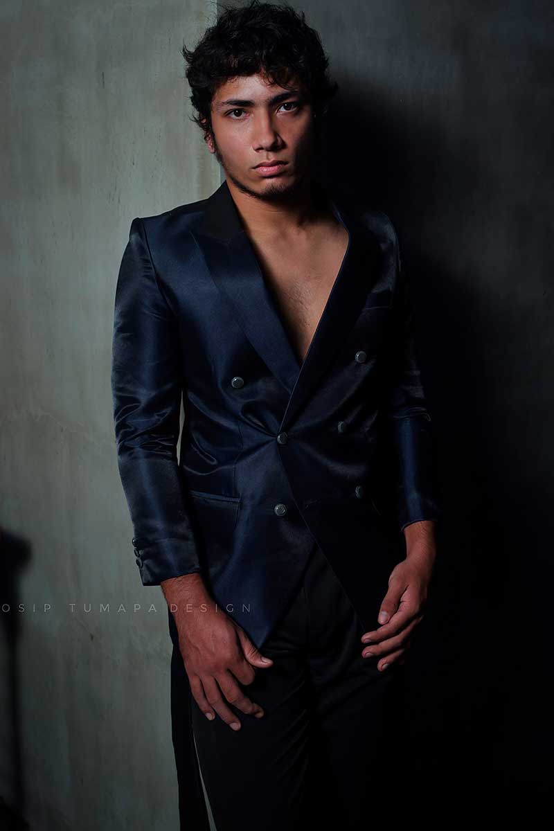 Deep-cut double-breasted menswear jacket worn directly on the body, creating a sharp evening silhouette