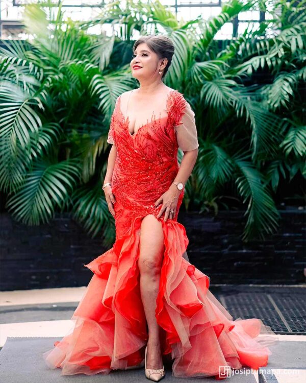 Custom-crafted red evening gown with intricate beading and a high slit, designed for elegance at upscale events