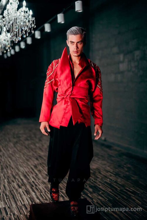 Red evening jacket styled as a single statement piece with high collar and clean lower line