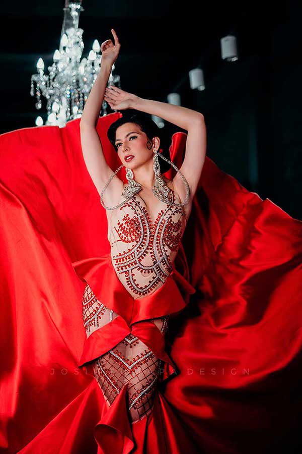 Red satin evening dress with sculpted beaded bodice and wide flowing skirt opening outward in motion