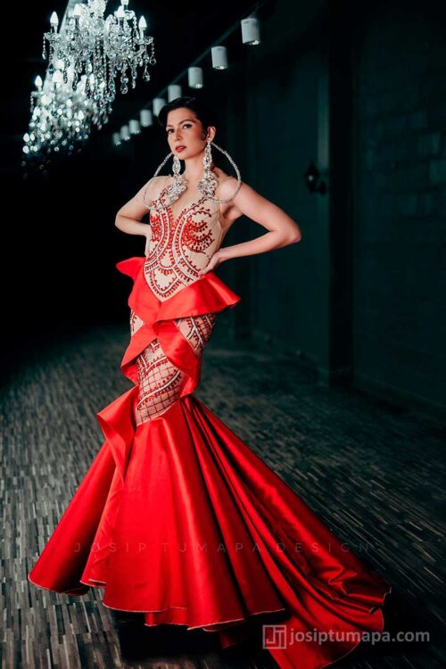 Front view of red evening dress with sheer mesh bodice, symmetrical bead embroidery, and controlled waist volume