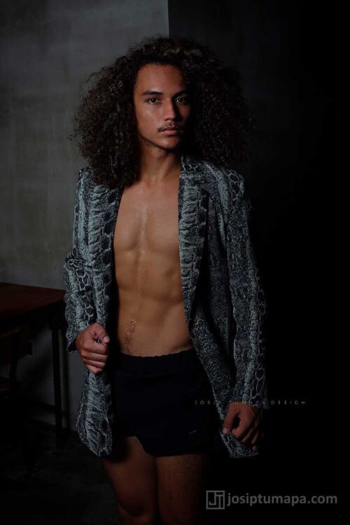 Open menswear jacket with dense snake-like pattern, clean lapel line, and long sleeves; the torso stays fully visible