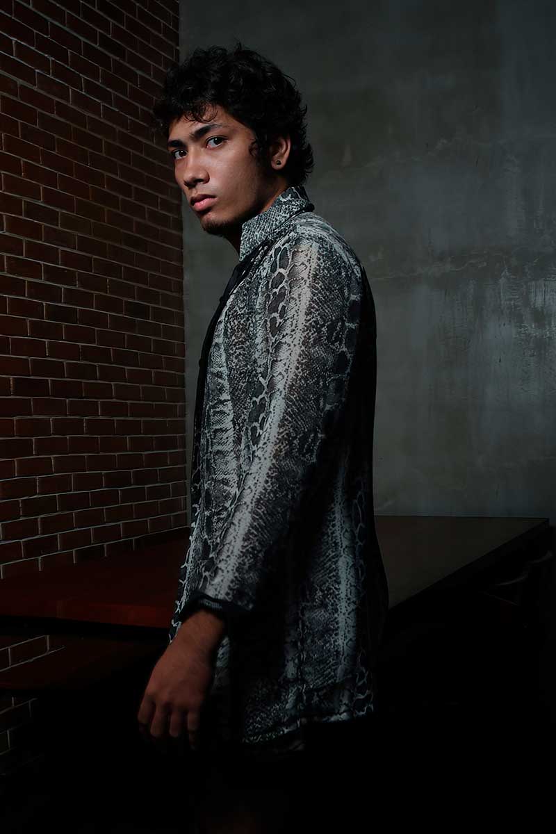 Men’s wrap-style jacket shown in profile, emphasizing textured surface, elongated vertical line, and calm structured silhouette