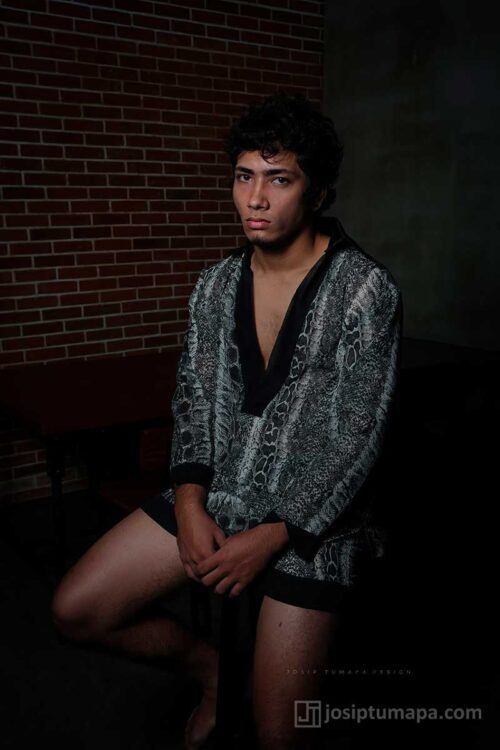 Men’s wrap jacket shown seated, highlighting soft drape, relaxed fit, and natural interaction with the body at rest