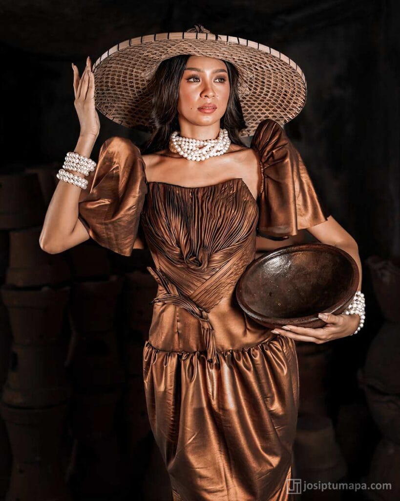Bronze sculpted Terno with ruched bodice, butterfly sleeves, woven hat and layered pearl accessories