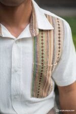 Close-up of textured tribal panel on white short-sleeve shirt