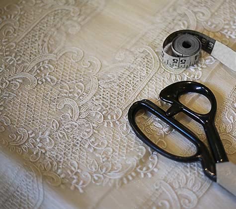 Piña Cocoon Silk fabric with soft embroidery, scissors, and tape measure—a blend of tradition, elegance, and tailoring craft