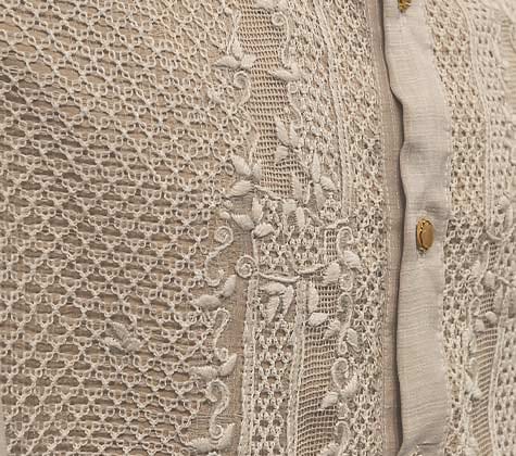 Close-up of hand-embroidered Piña fabric with delicate lacework and floral details, showcasing traditional Filipino craft