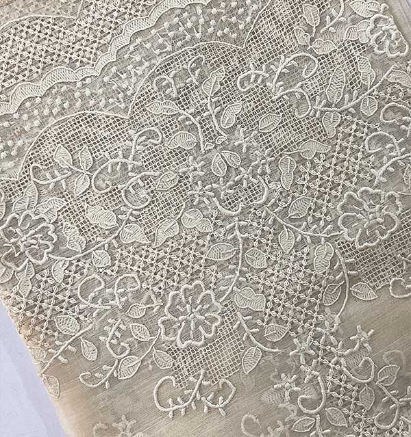 Close-up of hand embroidery on piña fabric with floral and calado motifs, showing artisan craftsmanship