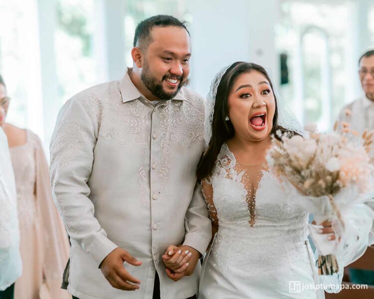 Filipino wedding couple indoors — groom wearing handcrafted Piña Cocoon Silk Coat Barong, bride in detailed lace gown
