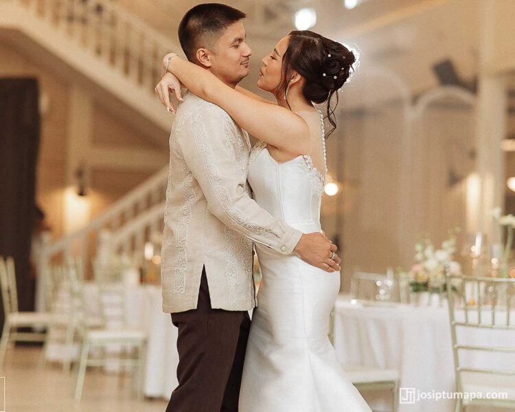 Bride and groom embracing during a formal celebration with the groom wearing a ceremonial Barong Tagalog