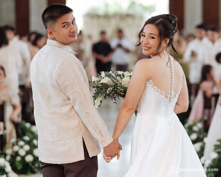 Bride and groom walking toward the ceremony with the groom wearing a formal Barong Tagalog, rear view