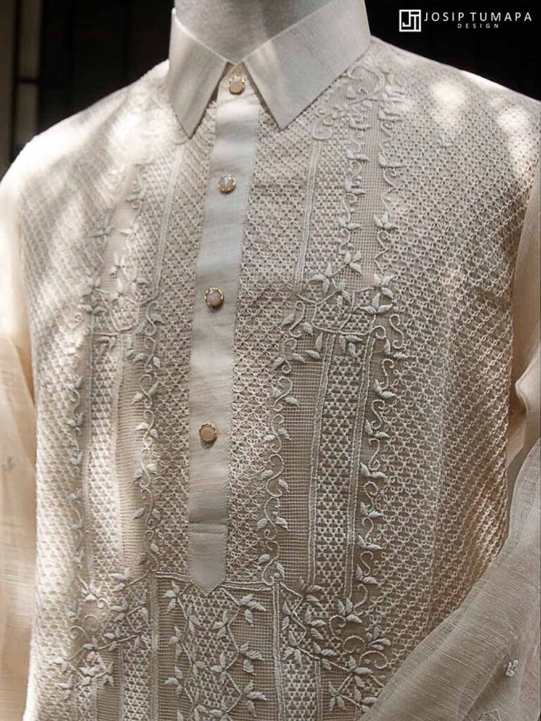 Close-up of a pure piña Barong Tagalog with calado openwork, hand embroidery, and botanical ornament on the front panel