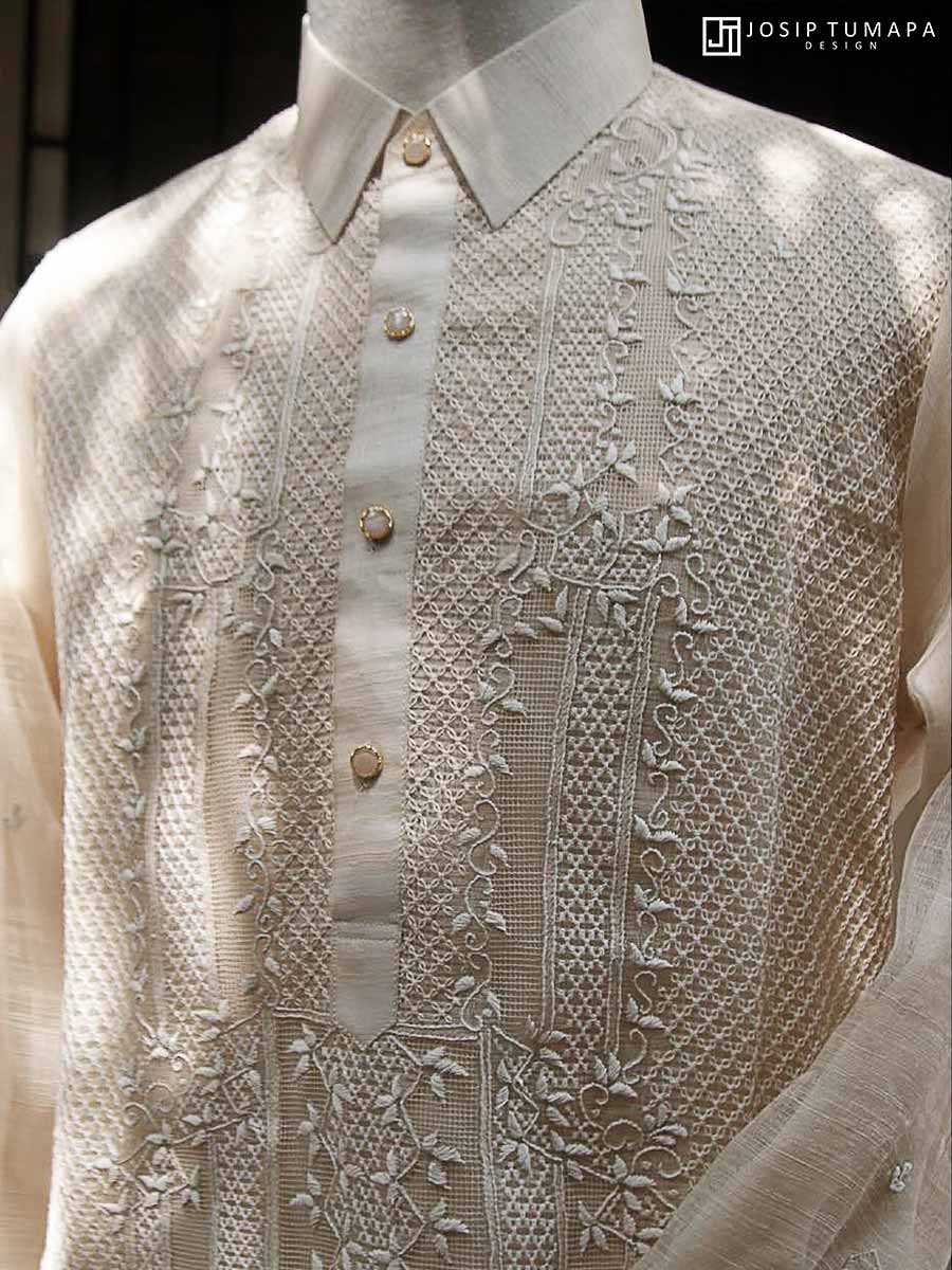 Close-up of a pure piña Barong Tagalog with calado openwork, hand embroidery, and botanical ornament on the front panel