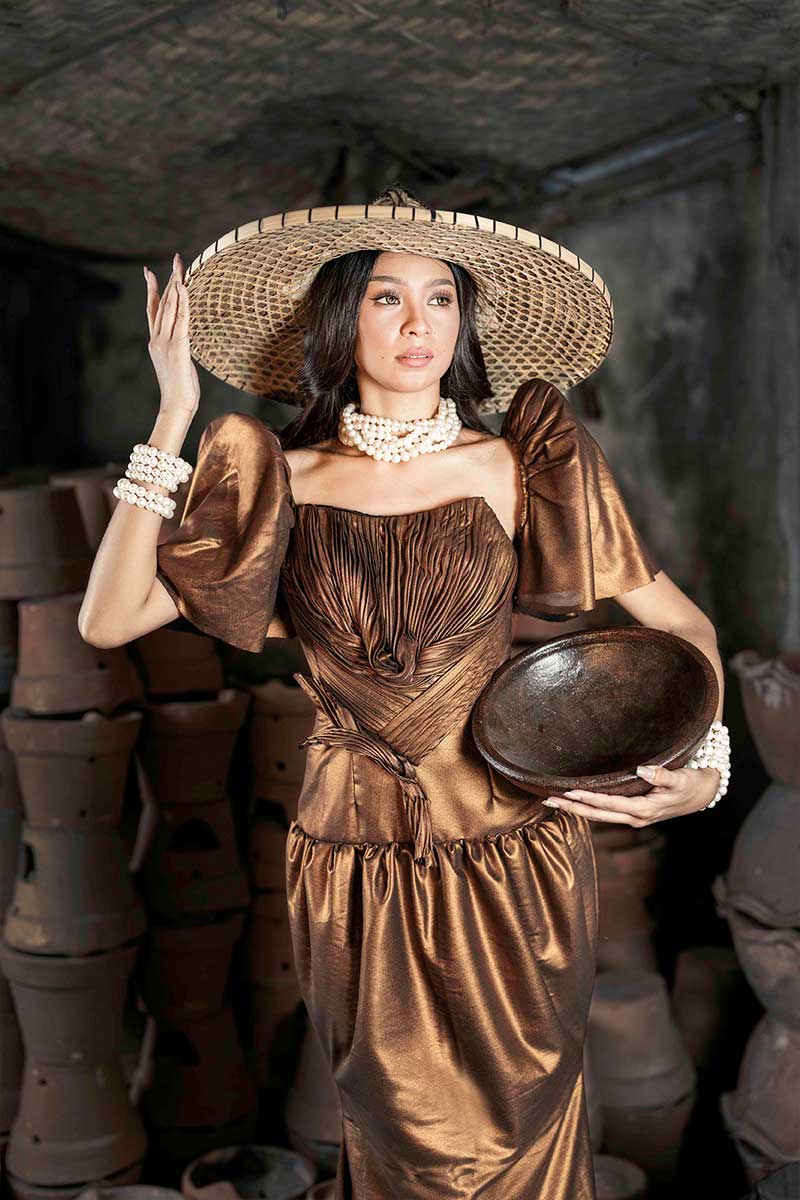 Filipiniana terno with sculpted bronze bodice, fluid skirt line, and traditional sleeve structure