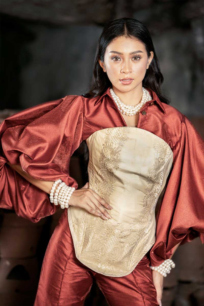 Scarlet terno ensemble in deep red silk with a piña cocoon silk corset, defined waistline, pearl accessories, and voluminous sleeves