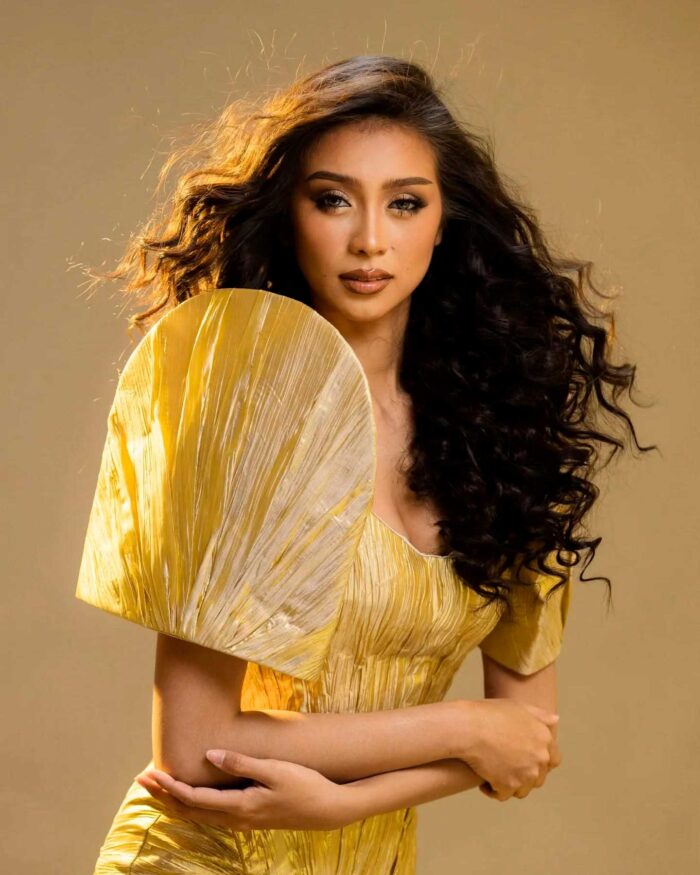 Close portrait of modern Filipiniana gown with terno-inspired sleeve and warm studio lighting
