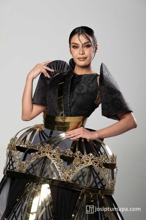 Black Filipiniana terno with butterfly sleeves, gilded waist detail, and architectural skirt inspired by a Kuna cradle