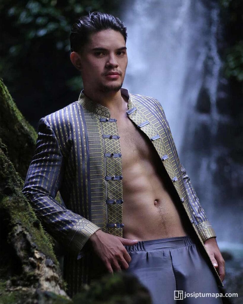 Close-up of patterned jacket with front closures, moss rock and waterfall behind