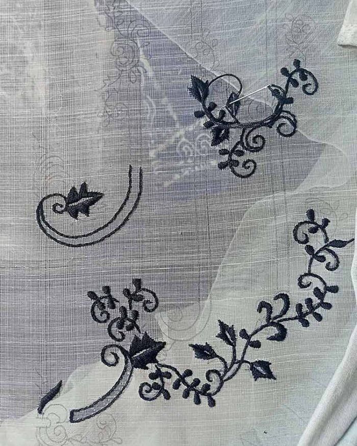 Hand Embroidery on Piña Silk Black hand embroidery being applied to piña silk fabric