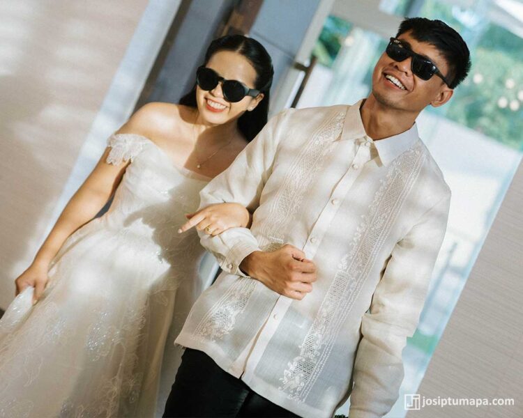 Groom wearing a lightweight Barong Tagalog with floral embroidery while walking with the bride at the reception