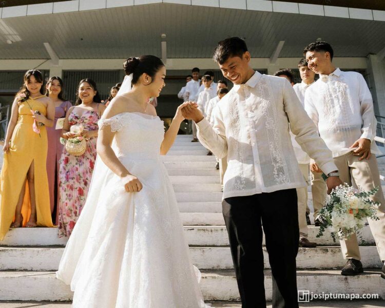 Groom in a Contemporary Barong Tagalog walking with the bride after an outdoor wedding ceremony