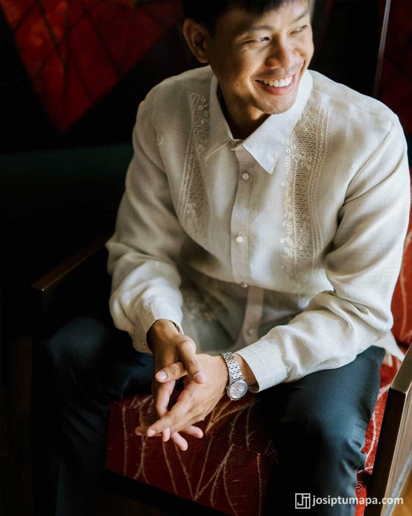 Groom wearing a piña cocoon silk Barong Tagalog with floral embroidery before an outdoor wedding